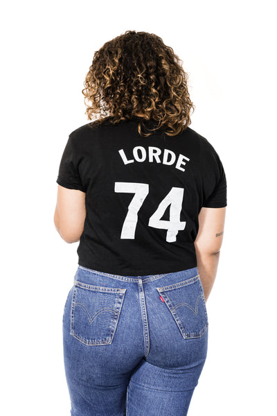 Back of Black female model wearing Audre Lorde #74 black crop baseball tee